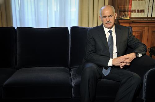 Greek Prime Minister George Papandreou listens to Greek President during their meeting at the Presidental Palace in Athens on November 5, 2011. [Xinhua]