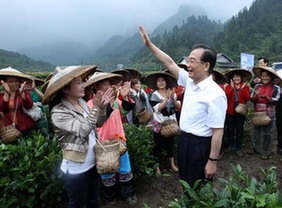 Chinese Premier Wen Jiabao (R, front) waves to tea pickers at the Shutouxi village of Guzhang county in the Tujia-Miao autonomous prefecture of Xiangxi, Central China's Hunan province, May 25, 2012.[ Photo / Xinhua ]